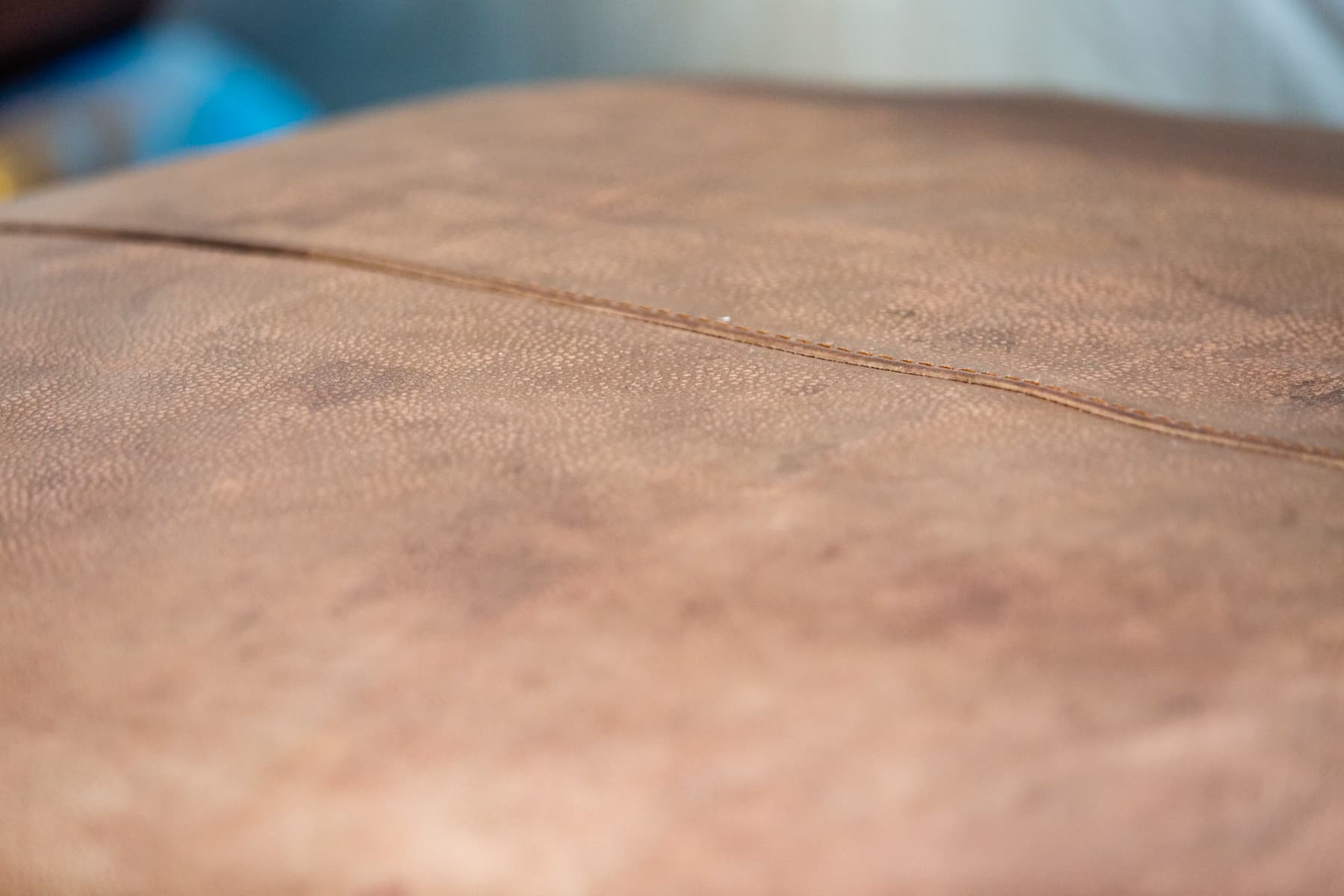 Close-up of visibly worn brown leather upholstery